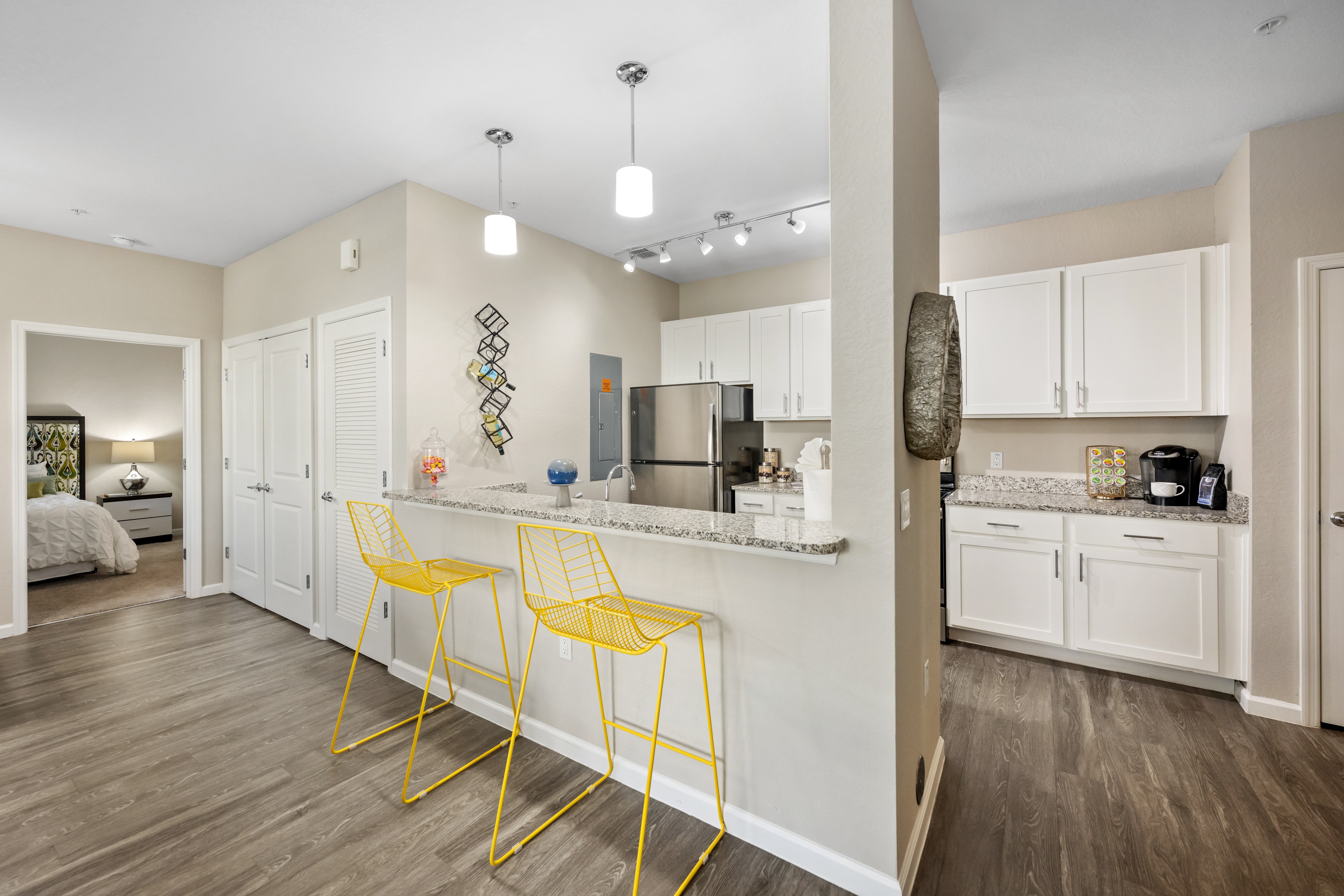 A kitchen with a bar area and yellow chairs.